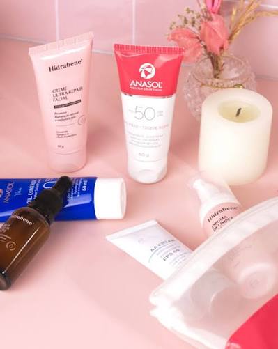 Skincare nacional: Hidrabene e protetor solar Anasol em bancada rosa
